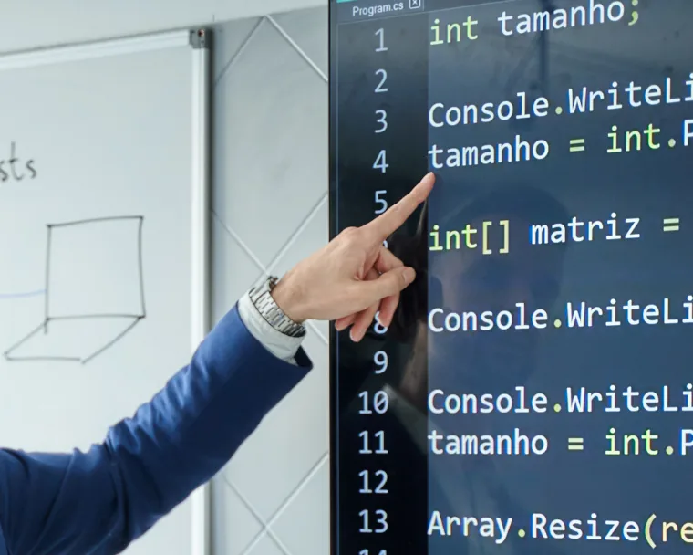Profesor explicando código en una pantalla durante una clase de Fomento FP