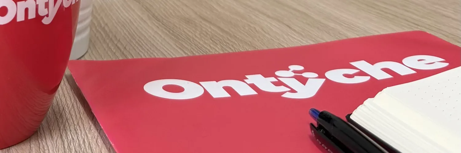 Taza y carpeta con el logotipo de Ontyche sobre la mesa de reuniones de la oficina